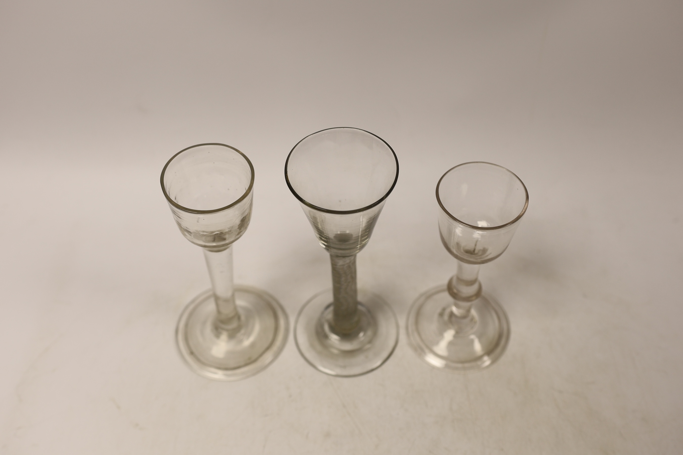 Three cordial glasses, first half 18th century, two with a folded foot, one with single knop and one with an incised twist stem, tallest 16cm